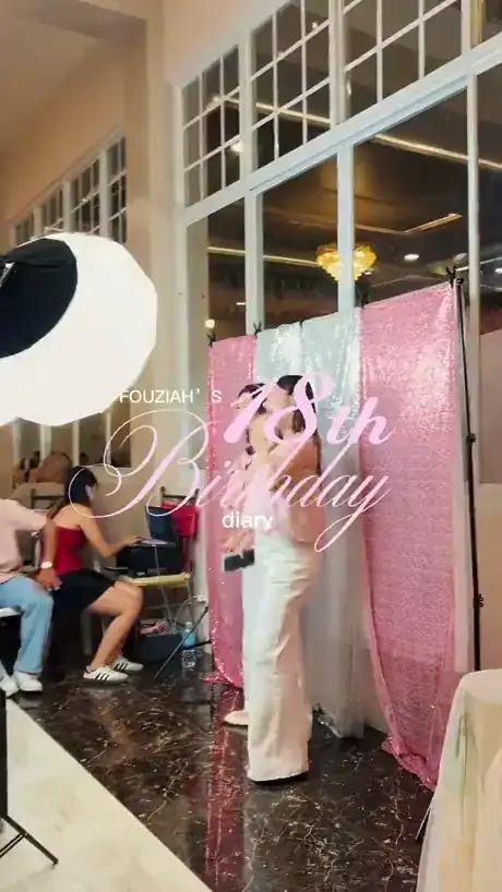 Photobooth with a pink backdrop and ring light at an 18th birthday party